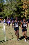 Alex Bett, junior computer science major, and Edwin Kurgat, freshman business administration major, round a corner during a cross country race.  - Photo by Deanna Santangelo