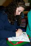Kaitlin Nonweiler, freshman Spanish major, fills out an information form to include in her box for Operation Christmas Child, one of the projects during Campus and Community Day. - Photo by Deanna Santangelo