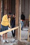 Glenae Nora, sophomore history major, sweeps insulation in the Neil House, an 1800s home that is currently being restored at Casey Jones Village. History students and faculty volunteered for the project as part of Campus and Community Day.  - Photo by Kristi McMurry