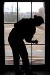 Megan Winters, junior history major, scrubs a window of the Neil House, an 1800s home that is currently being restored at Casey Jones Village. The home was recently moved to Jackson from Trenton, TN. History faculty and students helped with the restoration process as part of Campus and Community Day.  - Photo by Kristi McMurry