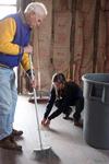 Stephen Carls, university professor of history and department chair, and Mary Ellen Poe, junior history major, sweep the floor of the Neil House, an 1800s home that has been relocated from Trenton, TN, to Casey Jones Village. The history department helped with the restoration as part of Campus and Community Day.  - Photo by Kristi McMurry