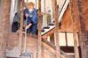 Elaura Highfield, junior history major, sweeps insulation at the 1800s home in Casey Jones Village. The Neil House was recently relocated from Trenton, TN, and the history department helped with the restoration process during Campus and Community Day.  - Photo by Kristi McMurry