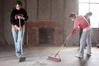 History majors Megan Winters, Savannah German, and Mary Ellen Poe, sweep the floor of the Neil House, the historic home that was recently relocated to Casey Jones Village from Trenton, TN. The history department volunteered to help with the restoration as part of Campus and Community Day.  - Photo by Kristi McMurry