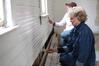 Judy Leforge, associate professor of history, helps paint an old church that is being restored at Casey Jones Village. The history department helped in the restoration as part of Campus and Community Day.  - Photo by Kristi McMurry