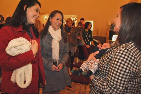 AlLee Browning, sophomore elementary education major, and Courtney Allen, junior social work major, visit with Ashley Jackson, Resident Director of Heritage Residence Complex, as they dote over her new baby, Titus, after the annual Christmas Story with the Dockerys. 