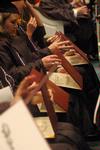 Graduates eagerly open their diploma at the December graduation ceremony at West Jackson Baptist Church. - Photo by Beth Spain