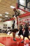Roland Banhoro, senior center, goes up for a basket against Bethel University defenders. The Bulldogs won the game 77-75.  - Photo by Ebbie Davis