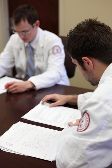Pharmacy students review their patient notes during class. 
