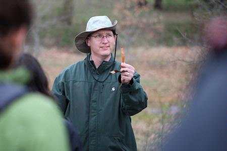 Andy Madison, associate professor of biology, shows his conservation biology students a leaf from a nearby tree during a field trip to the West TN Research & Education Center.