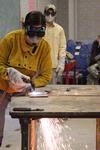 Haelim Allen, assistant professor of art, demonstrates to students how to operate the cutting torch for sculpture class.  - Photo by Kristi McMurry