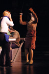 Molly Williams as Cassandra Hooper is being attacked by Miranda Wallace as Millie Standard while Patrick Myers as Marvin Standard reads the menu in the background in <i>You Have To Serve Somebody</i>. - Photo by Jim Veneman