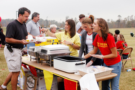 Members of Chi Omega serve barbeque to parents during Family Weekend 2003.