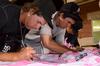 Nate Tenbrink (left), outfielder for the Jackson Generals, along with Anthony Vasquez, signs pink jerseys as part of the Union sponsored "shirt off your back" auction to support the American Cancer Society.  - Photo by Beth Spain