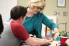 Cathy Huggins, director of biological laboratories, helps a student with an experiment in lab.  - Photo by Kristi McMurry