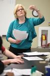 Cathy Huggins, director of biological laboratories, inspects the color of a liquid during a lab experiment.  - Photo by Kristi McMurry