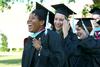Nadia Barnard and Sara Boyd, master of urban education graduates, walk to the Great Lawn for spring graduation. - Photo by Deanna Santangelo