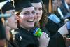 Kim Cryer, nursing graduate, cools herself down with a hand-held fan during spring graduation. - Photo by Deanna Santangelo