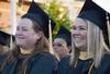 Master of Social Work graduates Cyndy Galewski and Theresa Guthrey watch their fellow classmates receive their diplomas at spring graduation. - Photo by Victoria Stargel