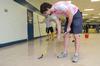 Stephen Capps, senior Biblical languages major, scrapes wax from the cafeteria floor at Lloyd Wood Middle School. Holt Elementary School will soon begin school here after water damage forced them to move to this previously vacant school building. - Photo by Beth Spain