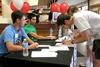 Scott Kahler, junior engineering major, and Stefan Rabenhorst, sophomore political science major, helps Jonathan Wunrow, brother of a new freshman, make a name tag. - Photo by Deanna Santangelo
