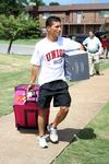 Brian Castro, sophomore athletic training major, carries a student's things during New Student Move-in. - Photo by Deanna Santangelo