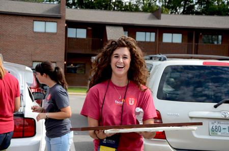 Megan Daniel, senior nursing major, assists incoming students moving in during New Student Move-in. 