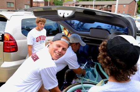 Krister Andreassen, sophomore sport management major, along with fellow soccer teammates helps unload cars during New Student Move-in. 