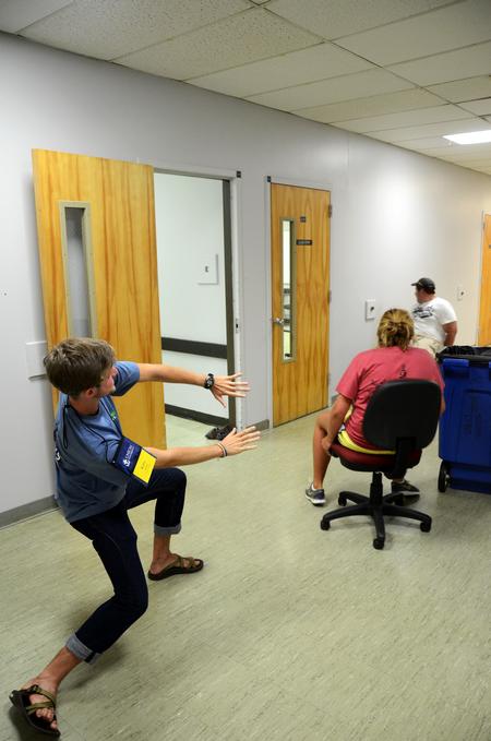 Kirby Lewis, junior chemistry major, helps freshmen in a rolling chair race during Focus week.