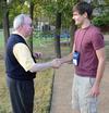 David S. Dockery, president of the university, shakes hands with freshman John Lutz during an ice cream social held outside the Dockery's home. - Photo by Jacob Moore