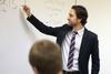 Jason Crawford, assistant professor of English, writes on the board as he lectures about tragedy.  - Photo by Kristi McMurry
