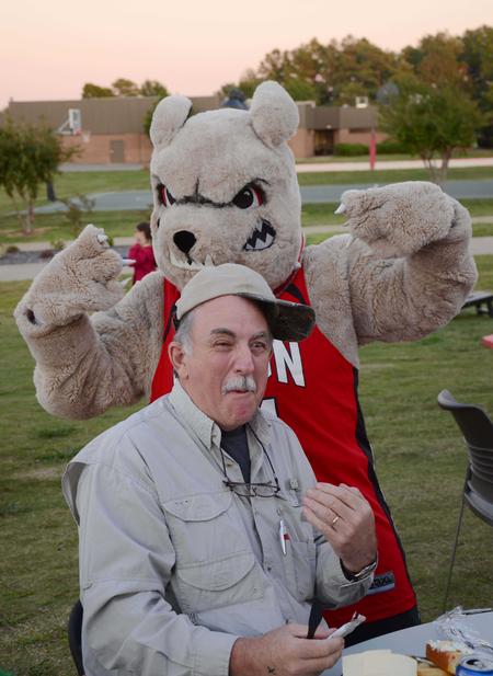 Buster the bulldog goofs off with the father of Travis Cross, sophomore physical science major, at the Make-a-wish cookout during Family Weekend. 