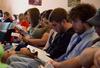 Students follow along in their Bibles during a scripture reading in chapel. - Photo by Jacob Moore