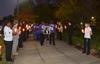 Families make their way to the great lawn holding photos of loved ones who were victims of homicide in West TN.  Union students and friends hold candles to honor these family members as they walk by. - Photo by Morris Abernathy