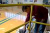Carl Chmielewski, senior nursing major, paints the railings in the gym at North Side High School, during Union's ninth annual Campus and Community Day. - Photo by Ebbie Davis