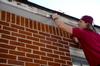 Jake Ryan, senior business administration major, prepares to repaint the trim of a local elderly woman's home during Campus and Community Day. - Photo by Ebbie Davis