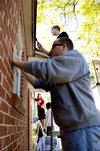 Jared Shumate, junior elementary education major, prepares to paint the trim of a home in Jackson as a part of Campus and Community Day. - Photo by Ebbie Davis