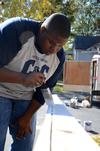 James Barbee, junior elementary education major, paints a railing at a Jackson home during Campus and Community Day. - Photo by Ebbie Davis