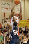 Energetic fans watch the Bulldogs force their way through the defense of the Lee University Flames to win the 2004 Homecoming game. Pierry Valmera (#44) is pictured here launching a jump shot over a Lee defender.  - Photo by Lindsay Stavish