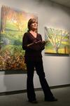 Lisa D. Line, a featured artist in the art gallery, talks to students and faculty about her art work during her gallery reception.  - Photo by Anne Richoux