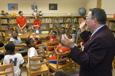 Following a demonstration by Neil Jackson (rear, left) and Sarah Perlinger, both chemistry majors, Dr. Charles M. Baldwin (far right), professor of pre-medical studies, explains the science behind the chemical reaction they have just viewed to second grade students at Whitehall Enhanced Community School on Friday. Union students take chemical demonstrations to students in east Jackson elementary schools through a grant from the American Chemical Society.