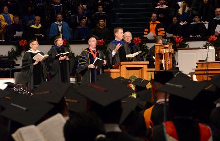 Chris Mathews, associate professor of music and department chair, leads graduates and their family and friends in a song during the 2011 Fall Commencement Services.
