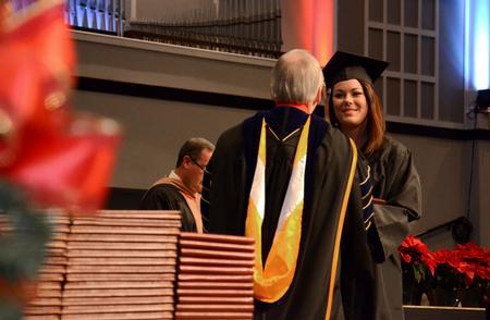 Brittany Marshall, business administration graduate, receives her diploma from David S. Dockery, president of the university, during the Fall Commencement Services held at West Jackson Baptist Church.