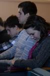 Kaitlyn Pindak (front), freshman music education major, and other students bow their heads during prayer after a message from Harry Reeder in chapel.  - Photo by Anne Richoux