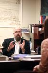Micah Watson, assistant professor of political science, talks with a student in his office. - Photo by Kristi McMurry