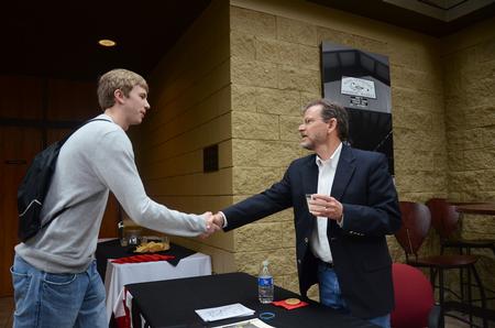 Michael Lewis, senior biology major, shakes hands with James Scruton, poet and head of the humanities division at Bethel College, after his poetry reading on campus.