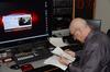 Steve Beverly, associate professor of communication arts, prepares the daily news cast for Jackson 24/7, produced in Jennings Hall.  - Photo by Ebbie Davis