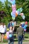 Cassie Robbers, sophomore art major, assists in making an arch of balloons stretching from the Penick Academic Complex to Miller Tower. - Photo by Jacob Moore
