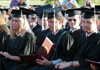 Broadcasting graduate Patrick Compau takes a first look at his diploma at spring commencement. - Photo by Kristen Hiller