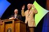 David S. Dockery, president of the university, presents keynote speaker Terry Bradshaw, former NFL quarterback and current FOX Sports analyst, with a Holman Christian Standard Bible with his name engraved on the front. Bradshaw shows excitement on receiving the gift.  - Photo by Ebbie Davis