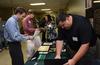 Junior engineering majors Brady Sheppard and Matt Wilson review information with General Cable company representatives Debra Eanes, human resources manager, and Neal Booker, engineering manager, during an engineering and technology expo. - Photo by Jacob Moore